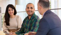 Two students conversing with a faculty member.